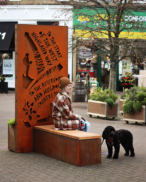 new gathering area in Milngavie formed of seating, planters, and interpretative elements